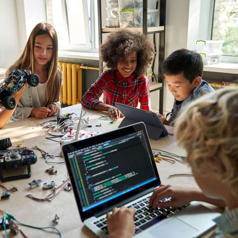 Kids working with technology and coding on the computer.